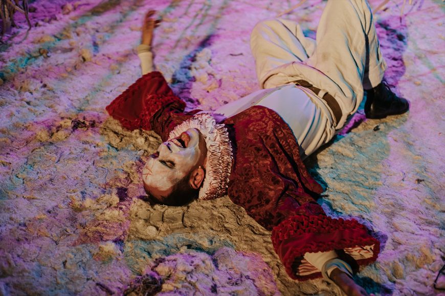 L'actor Jordi Vidal estirat al terra de l'escenari amb els braços oberts mentre canta en un  moment de l'espectacle
