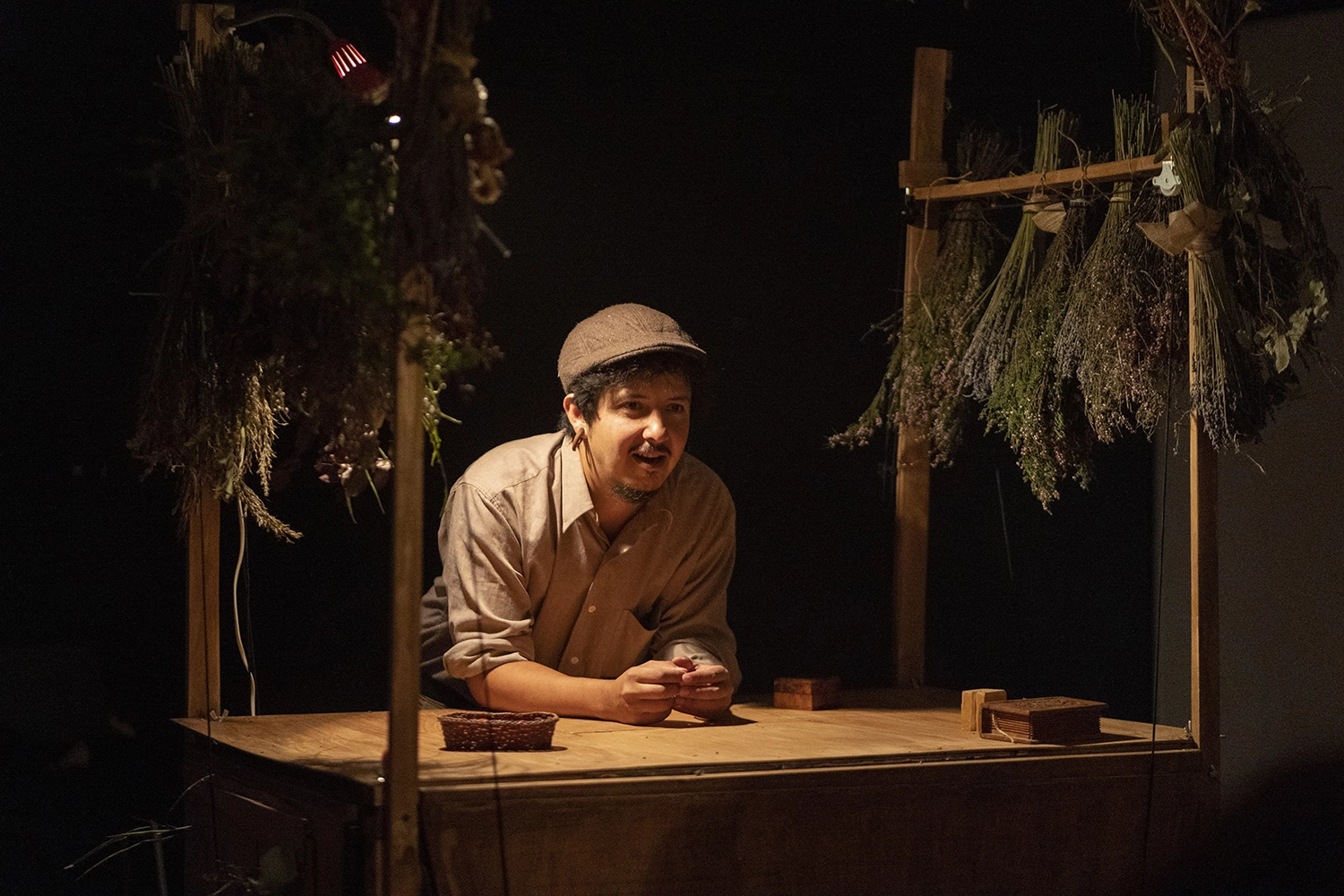 El actor Cristian Gómez apoyado en una mesa durante el espectáculo